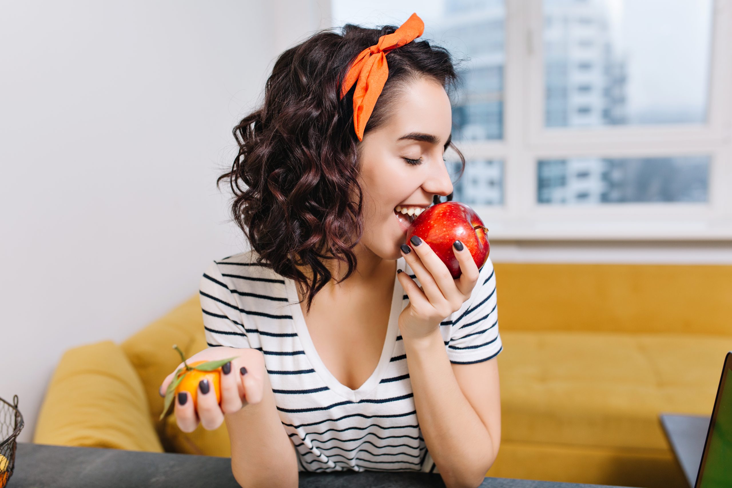 Lady biting apple showing how apples naturally clean teeth