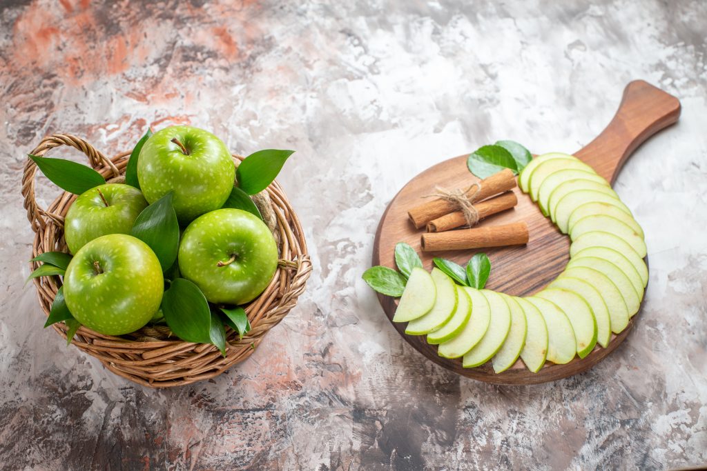 Sliced green apple showing juicy inside, with light background