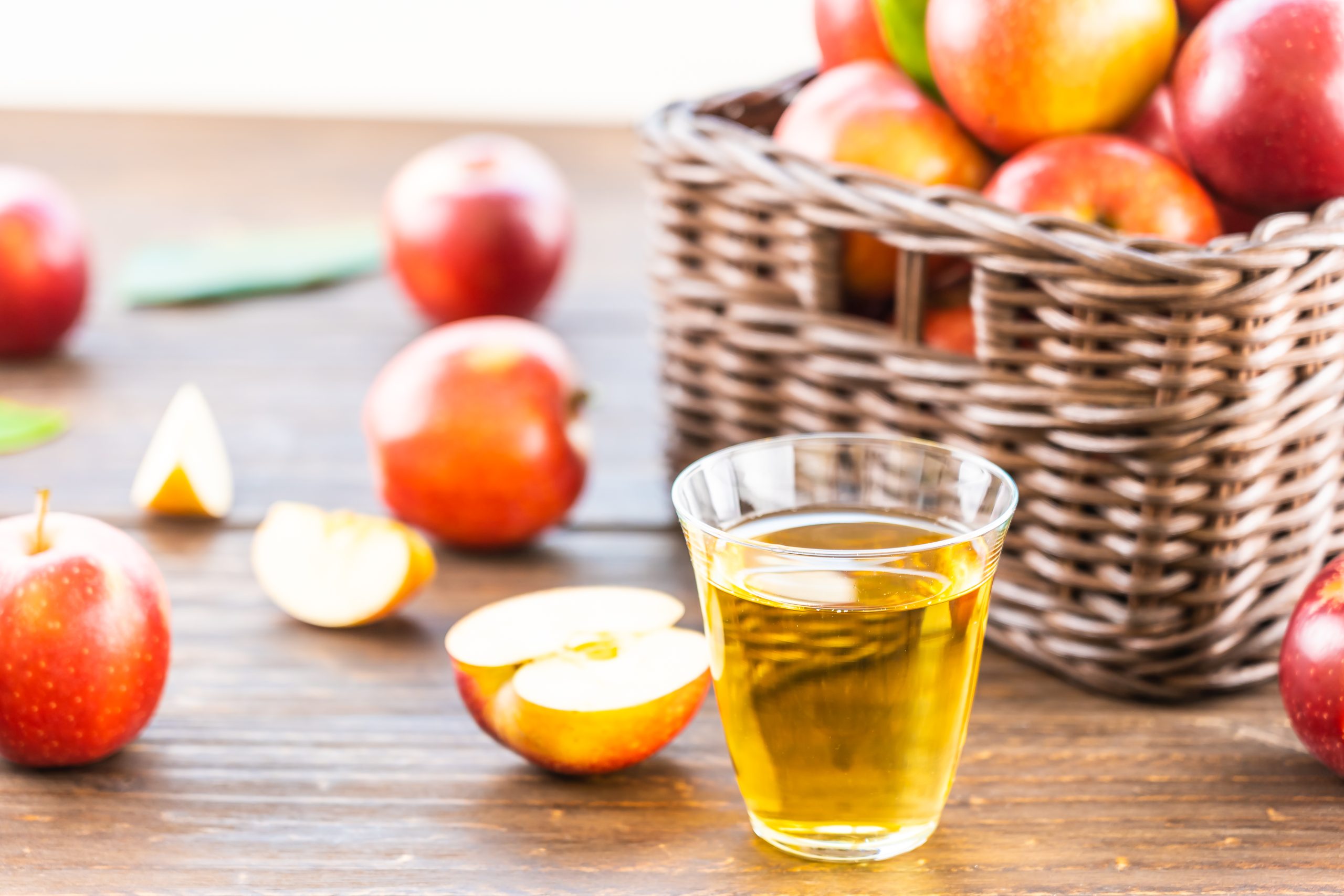 Apple's Cider Vinegar in a glass with red apple in the basket